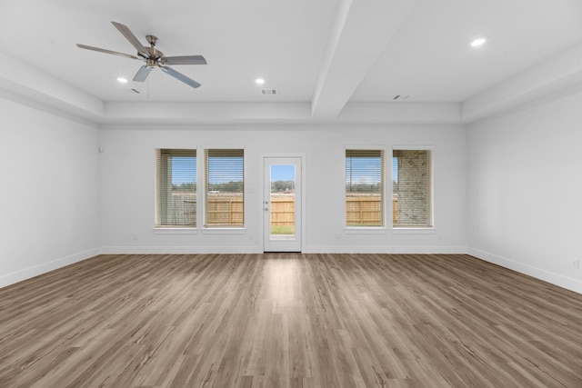 unfurnished living room featuring plenty of natural light, baseboards, and wood finished floors