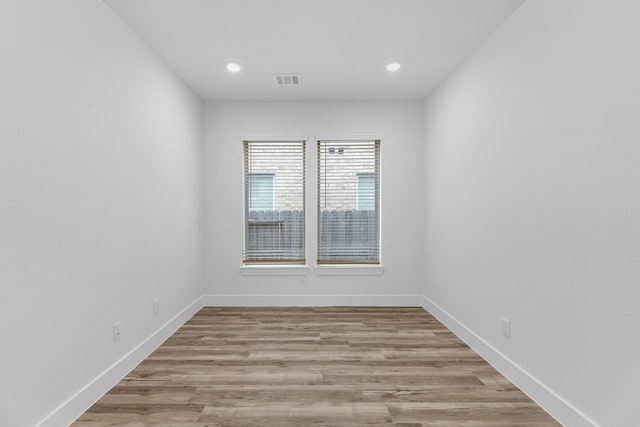 unfurnished room featuring recessed lighting, visible vents, baseboards, and wood finished floors