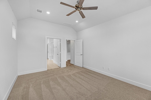 unfurnished bedroom featuring lofted ceiling, carpet flooring, baseboards, and visible vents