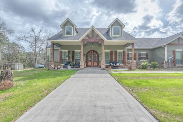 view of front of property featuring french doors, roof with shingles, a porch, and a front lawn