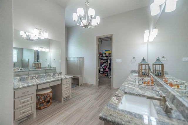 bathroom featuring wood finish floors, baseboards, a spacious closet, and vanity