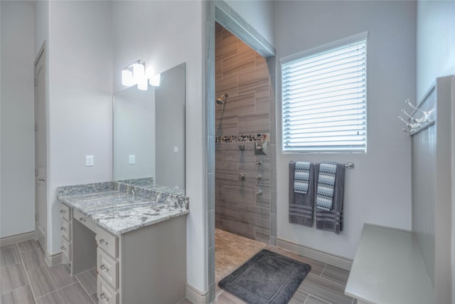 bathroom with baseboards, vanity, and walk in shower