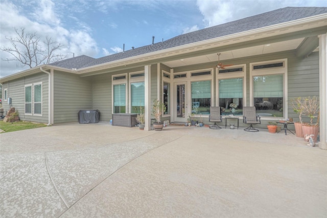 back of house featuring roof with shingles and a patio area