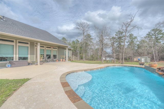 outdoor pool with a storage shed, a patio area, and an outdoor structure