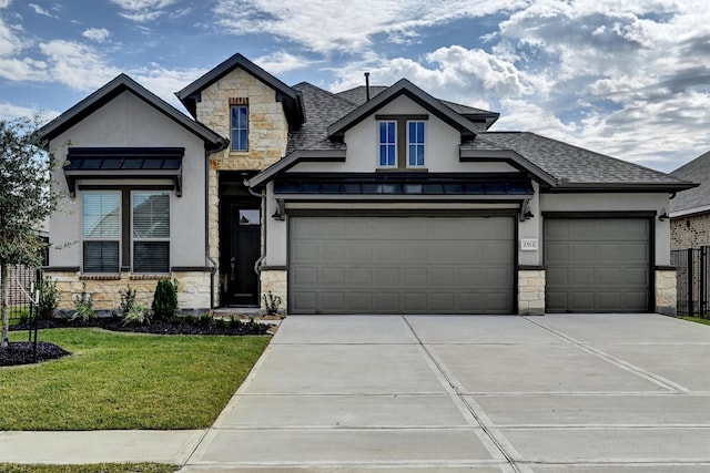 view of front of house with stucco siding, stone siding, driveway, and a front yard