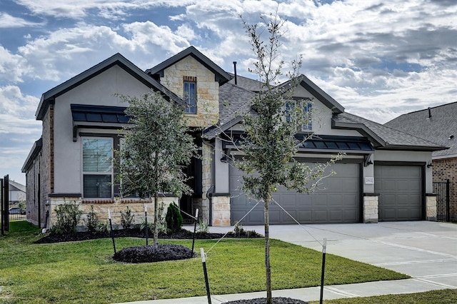 view of front of property featuring concrete driveway, a front yard, stucco siding, stone siding, and a standing seam roof