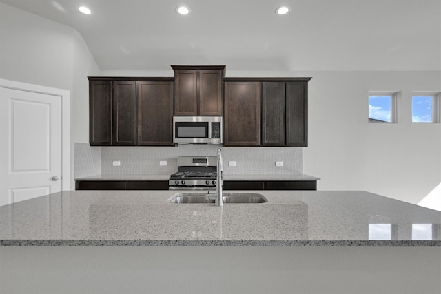 2512 Seneca Lake Dr, Texas City, TX 77568 - kitchen with appliances with stainless steel finishes, a sink, recessed lighting, dark brown cabinetry, and light stone countertops
