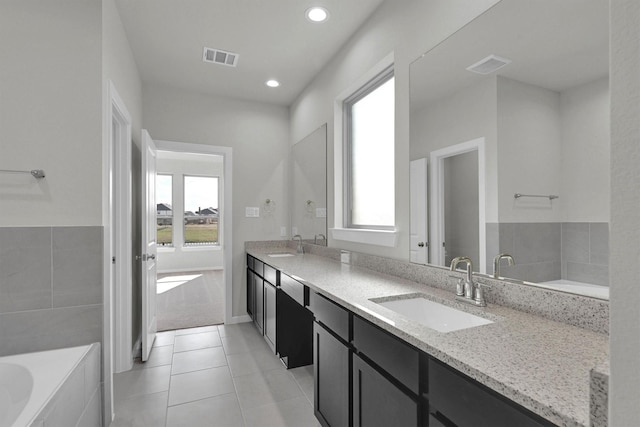 2512 Seneca Lake Dr, Texas City, TX 77568 - bathroom with double vanity, tile patterned floors, a bathtub, and recessed lighting