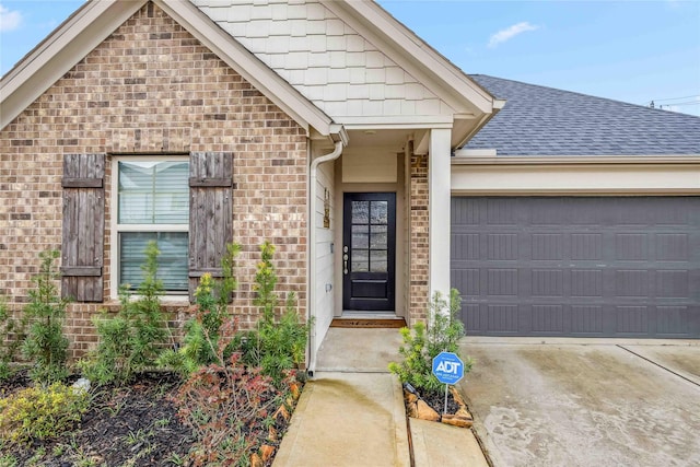 view of front of home featuring brick siding, roof with shingles, concrete driveway, and an attached garage