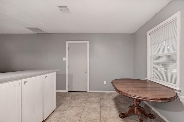 dining area with light tile patterned floors, visible vents, and baseboards