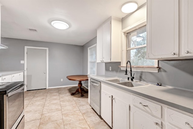 kitchen with visible vents, a sink, stainless steel appliances, white cabinets, and light tile patterned floors