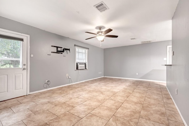 empty room featuring ceiling fan, visible vents, baseboards, and cooling unit