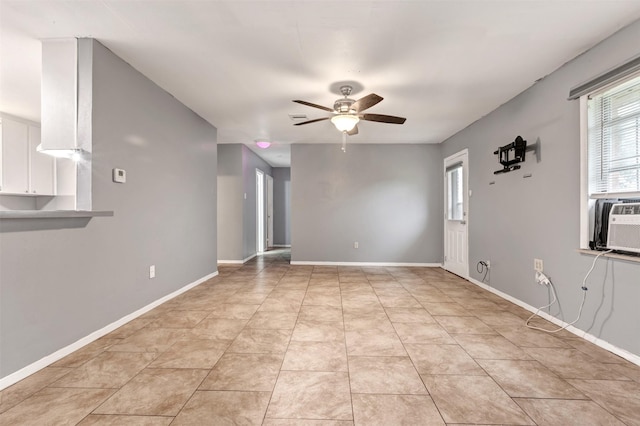 spare room featuring light tile patterned flooring, baseboards, and ceiling fan