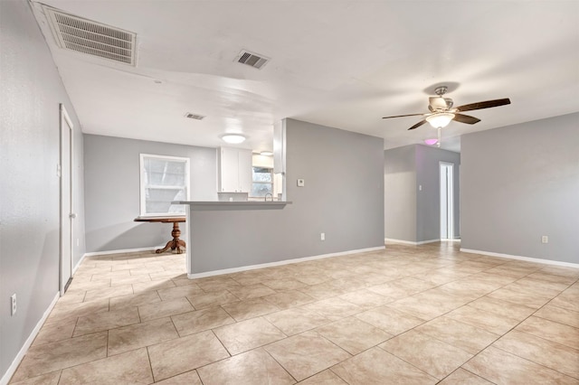 unfurnished room featuring light tile patterned floors, visible vents, baseboards, and ceiling fan