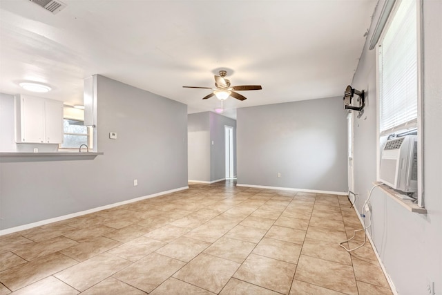 unfurnished room featuring visible vents, baseboards, cooling unit, light tile patterned flooring, and a ceiling fan