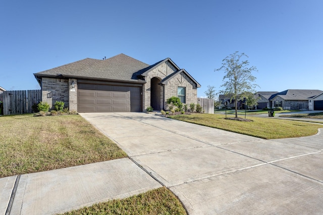 view of front of house with fence, concrete driveway, a front yard, a garage, and brick siding