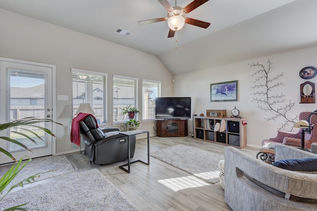 living area with visible vents, ceiling fan, baseboards, light wood-type flooring, and lofted ceiling