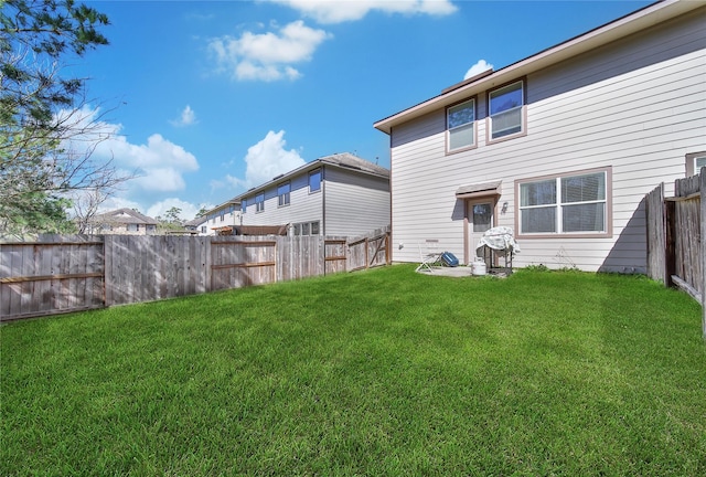 back of house featuring a yard and a fenced backyard