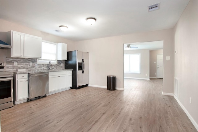 kitchen featuring decorative backsplash, plenty of natural light, visible vents, and stainless steel appliances