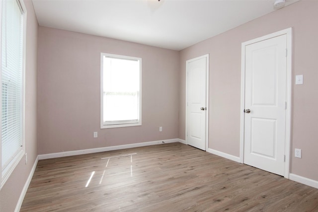 unfurnished bedroom with light wood-style flooring and baseboards