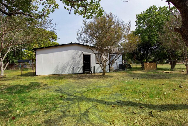 exterior space featuring central AC and fence