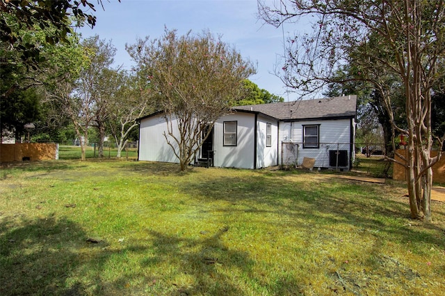 view of yard featuring central AC unit and fence