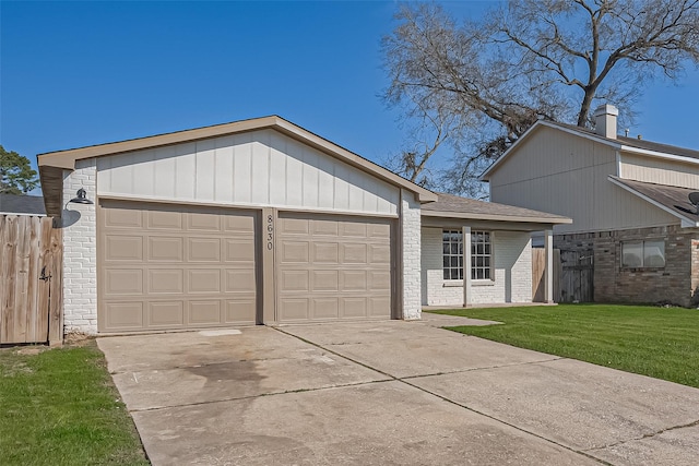 view of front of home with brick siding, fence, a front yard, driveway, and an attached garage