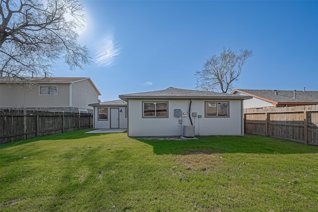 rear view of property with a lawn and a fenced backyard