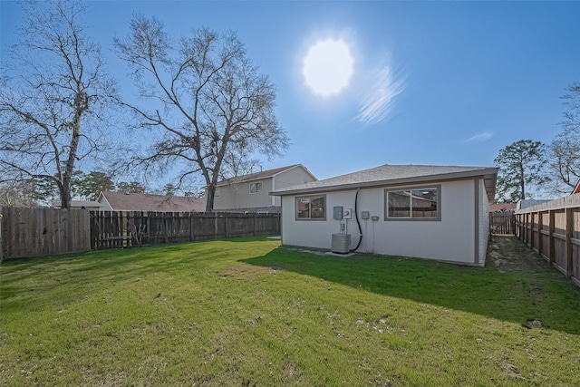 back of house featuring cooling unit, a lawn, and a fenced backyard