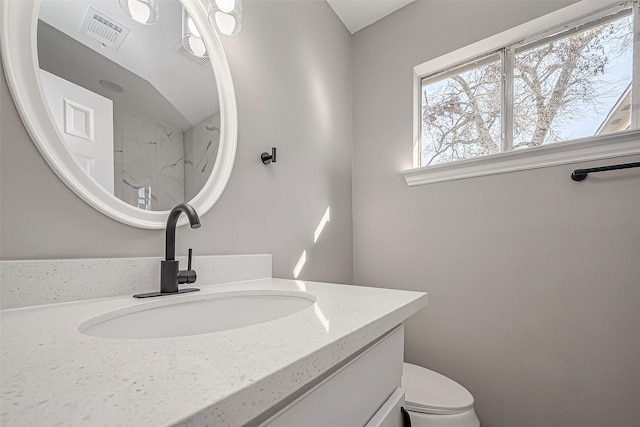 bathroom with visible vents, toilet, and vanity