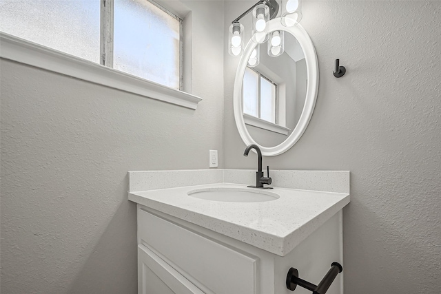 bathroom with vanity and a textured wall