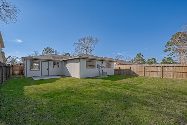 back of property featuring a yard, a fenced backyard, and central AC