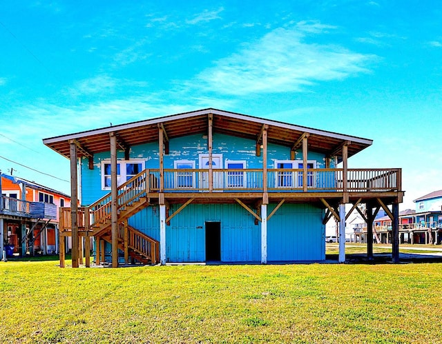 rear view of property with a yard, a wooden deck, and stairs