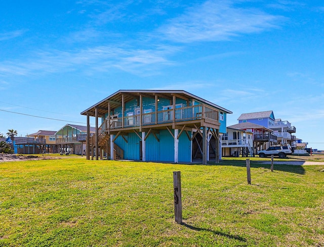 rear view of property featuring a lawn, stairs, and a deck