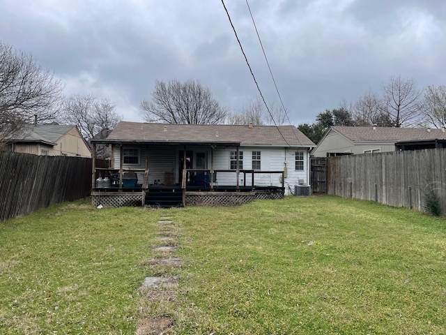 rear view of house featuring a yard, a wooden deck, central AC, and a fenced backyard