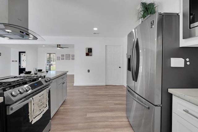 kitchen with light wood-type flooring, visible vents, a ceiling fan, stainless steel appliances, and exhaust hood