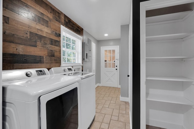 washroom featuring wooden walls, baseboards, and separate washer and dryer