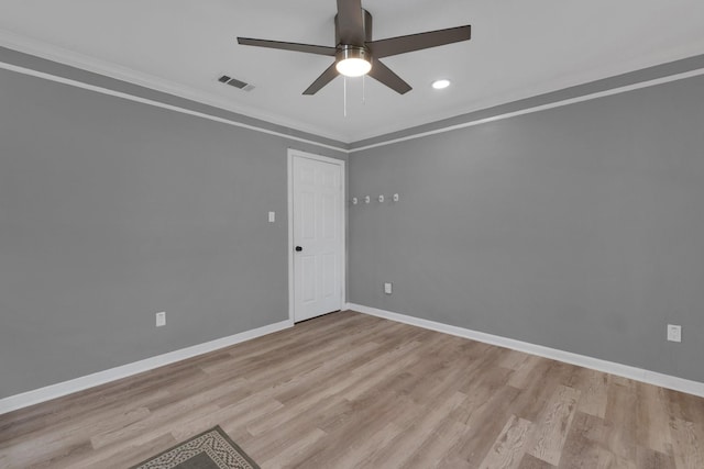 unfurnished room featuring ornamental molding, baseboards, visible vents, and light wood-type flooring