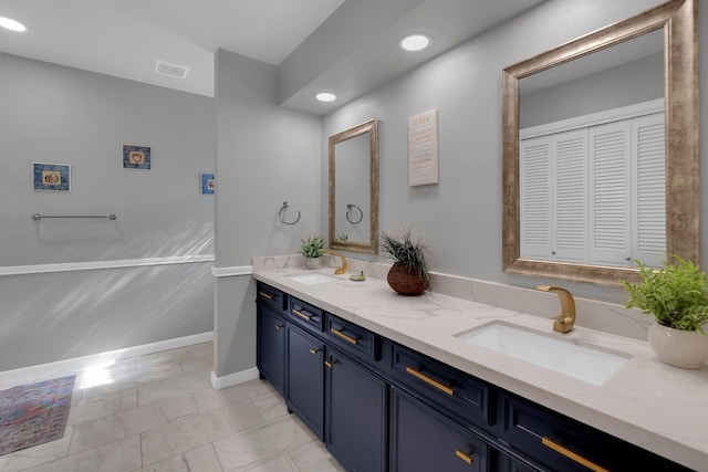 bathroom featuring a sink, visible vents, marble finish floor, and double vanity