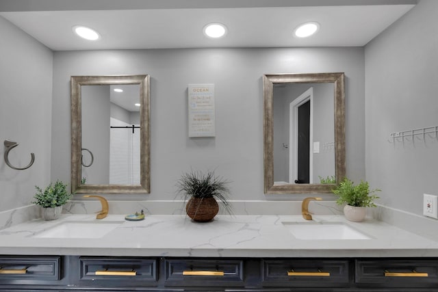 full bathroom with double vanity, recessed lighting, a shower stall, and a sink