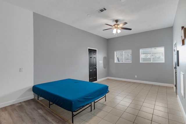 interior space with visible vents, baseboards, light tile patterned flooring, and a ceiling fan