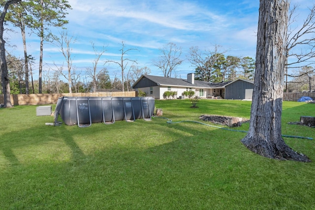 view of yard featuring a fenced in pool and fence