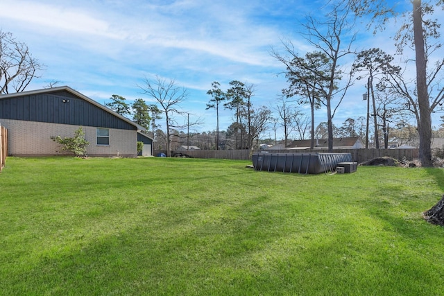 view of yard with central AC unit, a pool, and fence