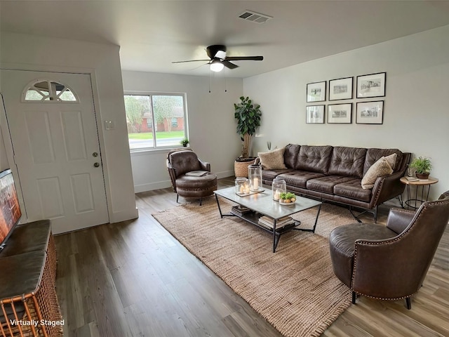 living room with visible vents, a ceiling fan, baseboards, and wood finished floors