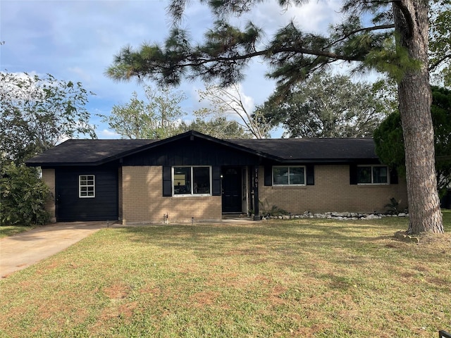 single story home featuring brick siding, concrete driveway, and a front yard