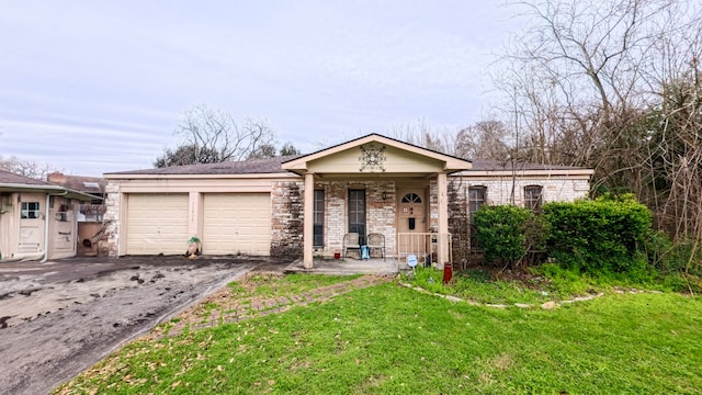 view of front of house featuring a porch, driveway, an attached garage, and a front yard