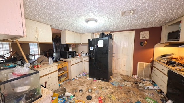 kitchen featuring visible vents, a textured ceiling, black appliances, and light countertops