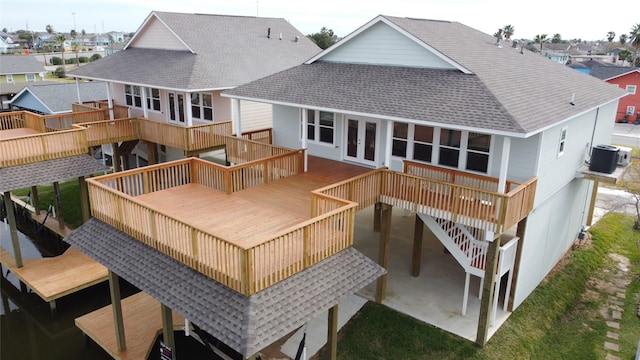 rear view of house featuring central air condition unit, french doors, a shingled roof, and a patio