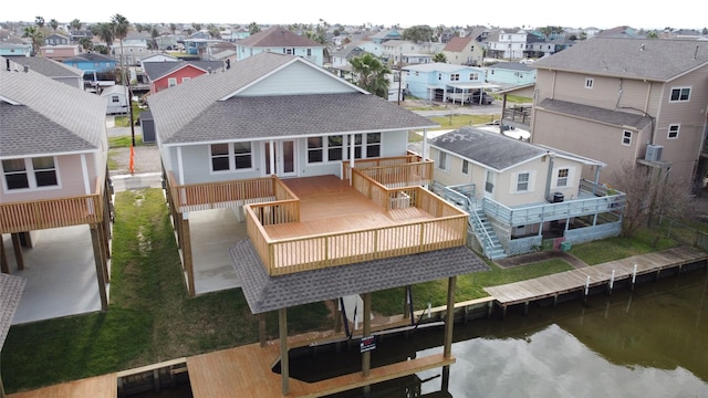 rear view of property with a residential view, a shingled roof, and a deck with water view