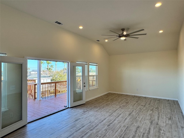 unfurnished room featuring a ceiling fan, wood finished floors, visible vents, baseboards, and lofted ceiling